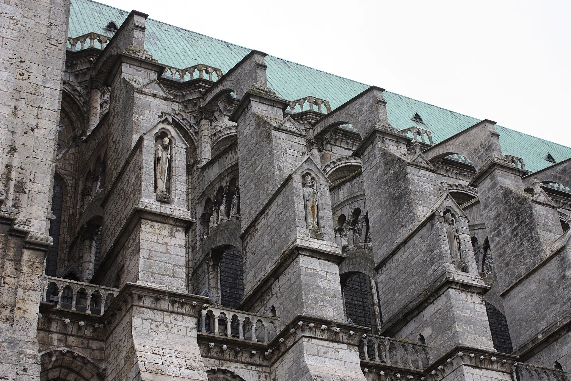Detalle exterior de Chartres: arbotantes escalonados, contrafuertes y figuras esculpidas.