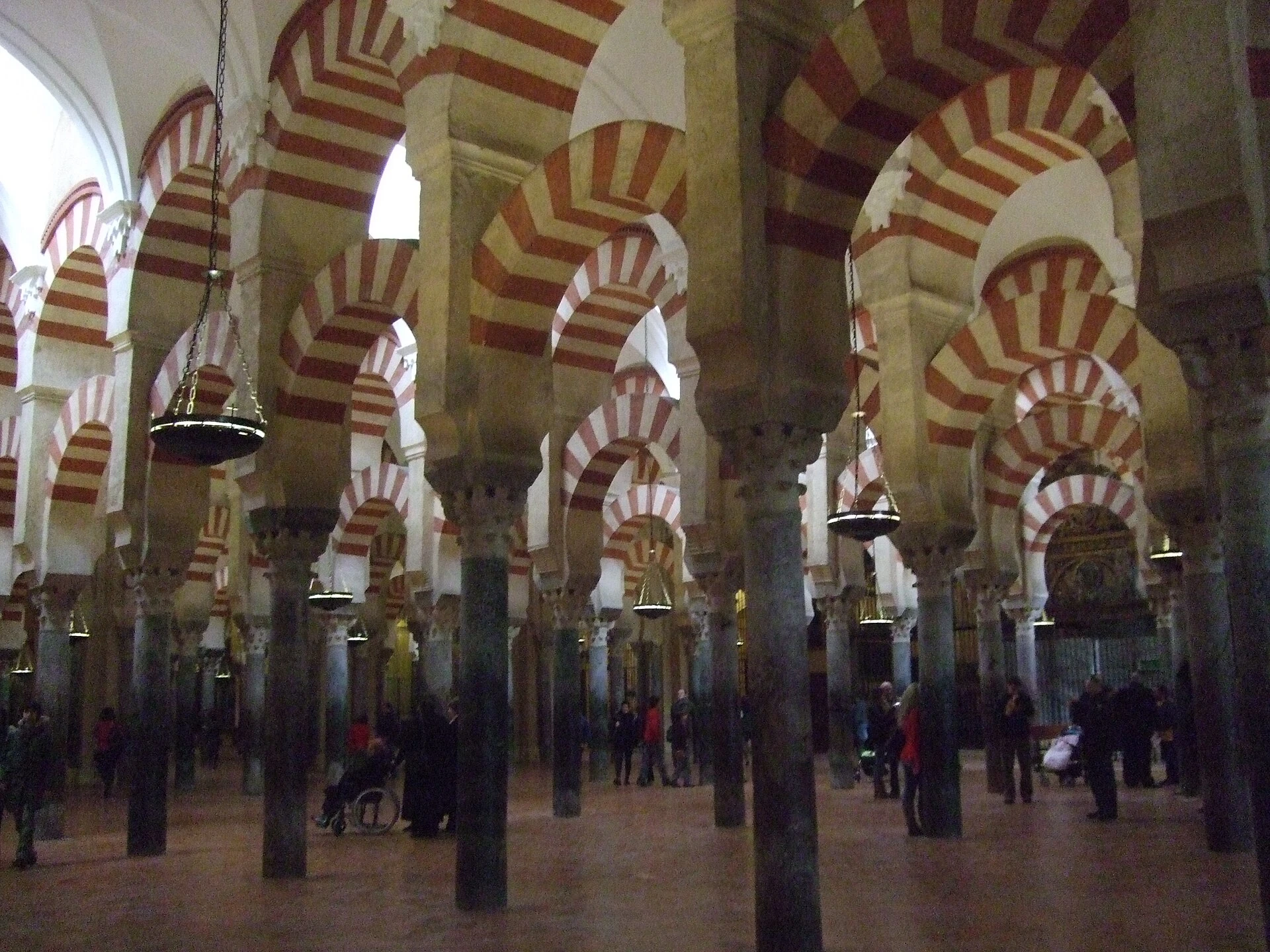 Sala de oración de Córdoba con columnas y dos niveles de arcos de dovelas rojas y blancas.